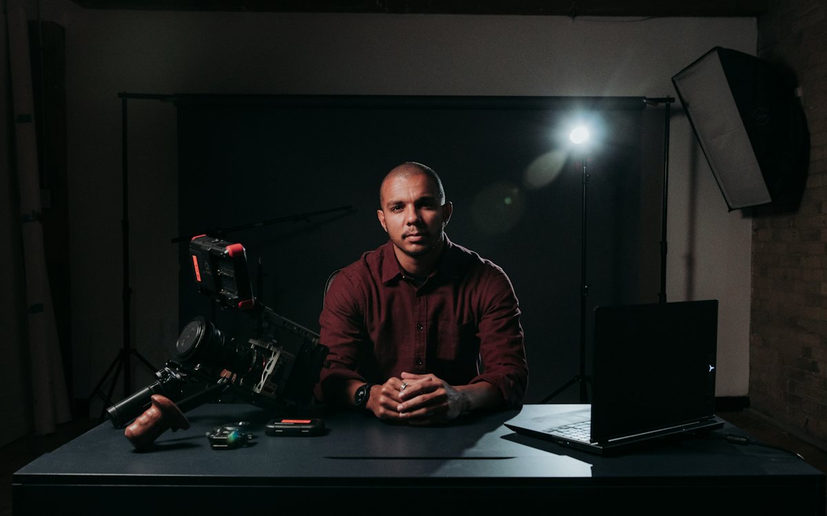 Person seated in front of a camera and lights in a dark casting studio